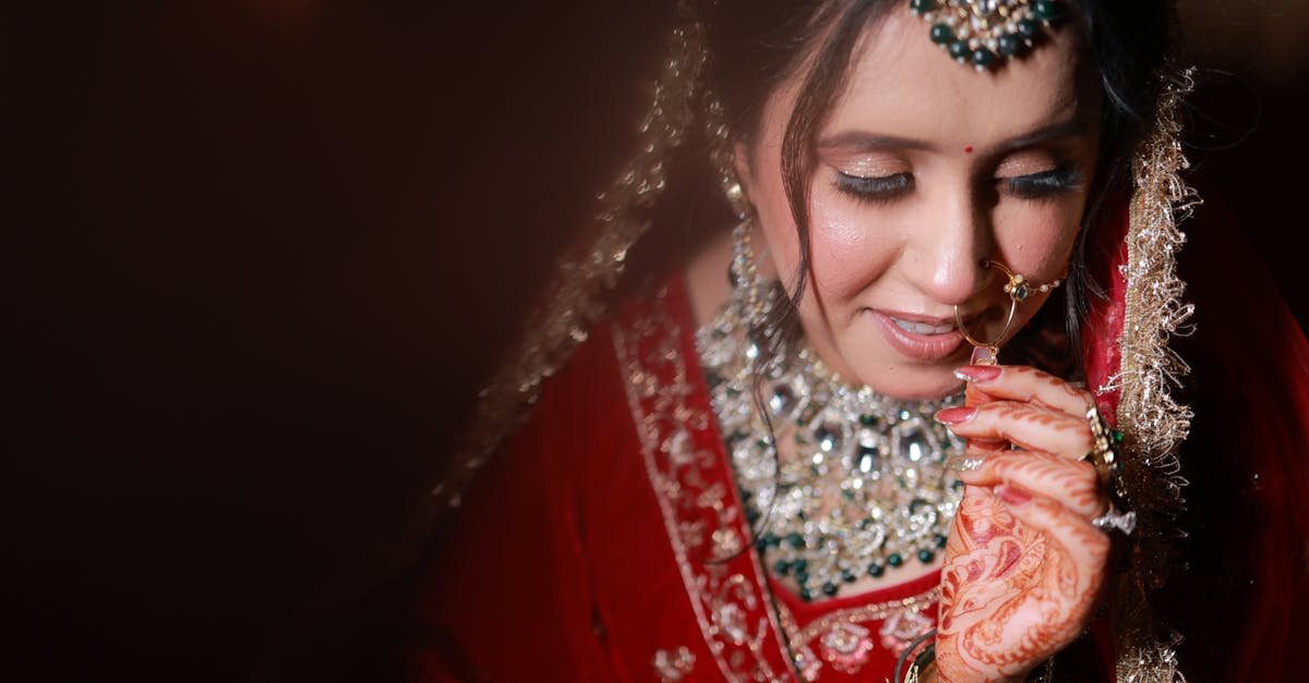 Portrait of a South Asian bride adorned in traditional red bridal attire, showcasing intricate jewelry and henna designs.