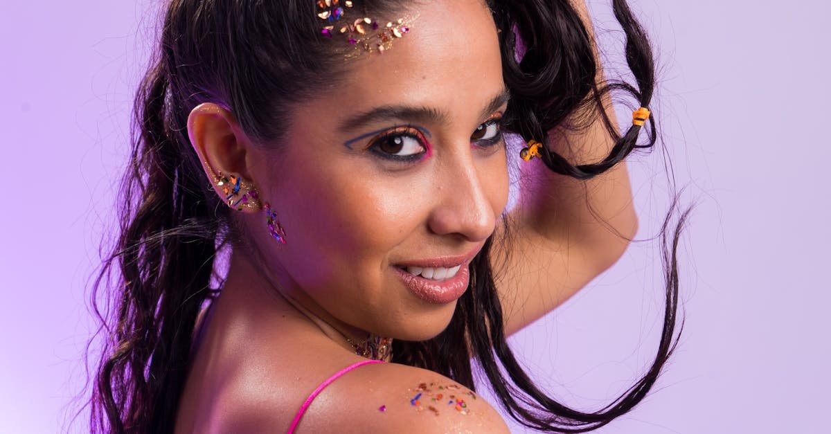 Portrait of a woman with glitter and bold makeup in a studio setting.